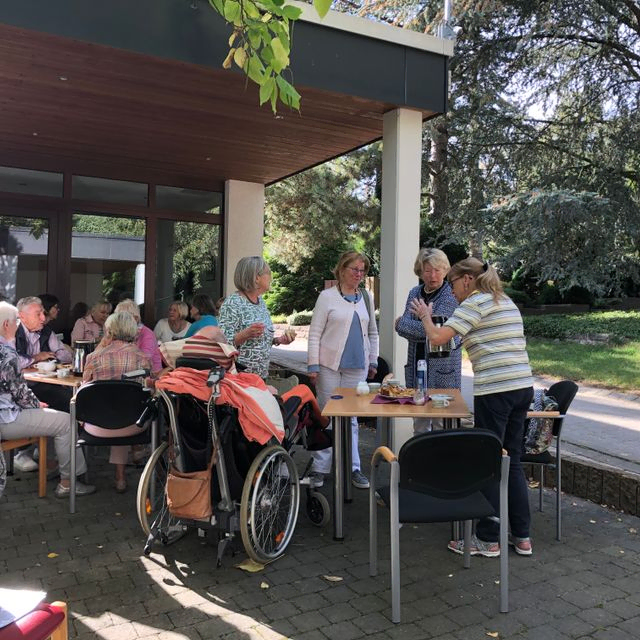 Gemeindemitglieder bei Kaffee und Gemeinschaft auf der Terrasse.