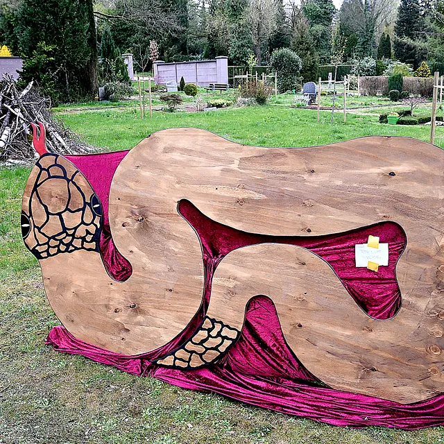 Kunstwerk in Schlangenform auf dem Friedhof, das Versuchung symbolisiert.