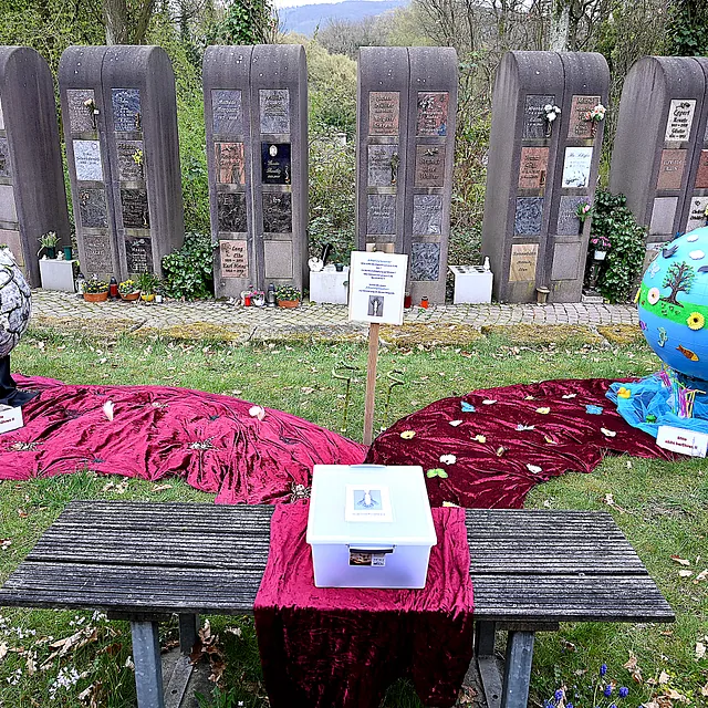Kunstinstallation mit zwei Kugeln, die Schöpfung auf dem Friedhof symbolisieren.